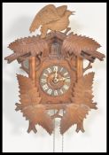 A 20th Century carved black forest cuckoo wall clock having two weights having roman numerals to the