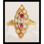 A 9ct gold seed pearl, ruby and diamond ring in lozenge set channel mount. The central round cut