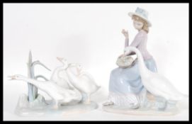 A Lladro ceramic figurine group depicting a girl with geese along with another Lladro figurine group