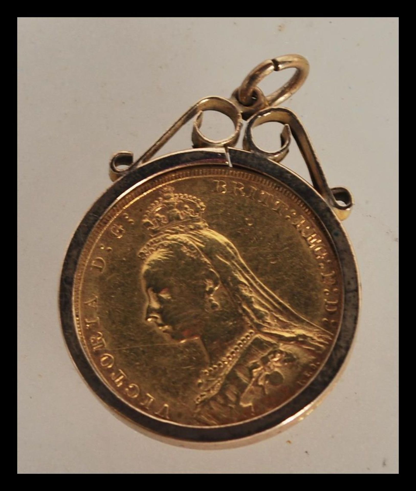 A 19th Century Victorian full sovereign dated 1890 set within a hallmarked 9ct pendant clasp.