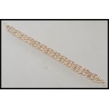 An early 20th Century unmarked 9ct gold decorative lattice work linked bracelet. Unmarked but