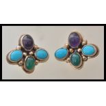 A pair of Art Deco style sterling silver earrings being set with turquoise and amethyst cabochons.