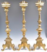 A SET OF THREE EARLY 19TH CENTURY GEORGIAN BRASS ALTAR CANDLESTICKS.