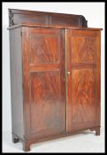 AN EARLY 19TH CENTURY FLAME MAHOGANY BOOKCASE CABINET HAVING SCROLLED GALLERY TOP