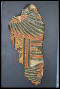 AN EGYPTIAN SARCOPHAGUS FRAGMENT BEING PAINTED IN RED, BLUE AND BLACK
