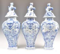 A SET OF THREE ANTIQUE DELFT BLUE AND WHITE JARS AND COVERS.
