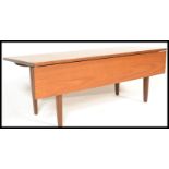 A retro 20th Century teak wood gate leg flap extendable coffee table, single leaf raised on tapering