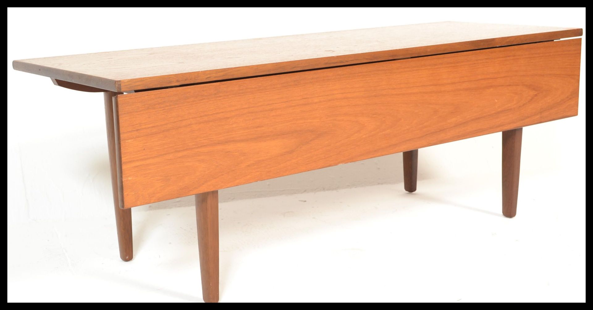 A retro 20th Century teak wood gate leg flap extendable coffee table, single leaf raised on tapering