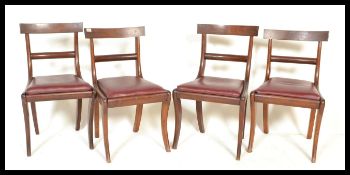 A set of 4 19th century mahogany Regency bar back dining chairs being raised on sabre legs with drop