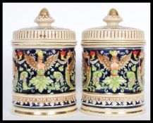 A pair of 20th Century German ceramic biscuit barrels / tobacco jar pots having hand painted