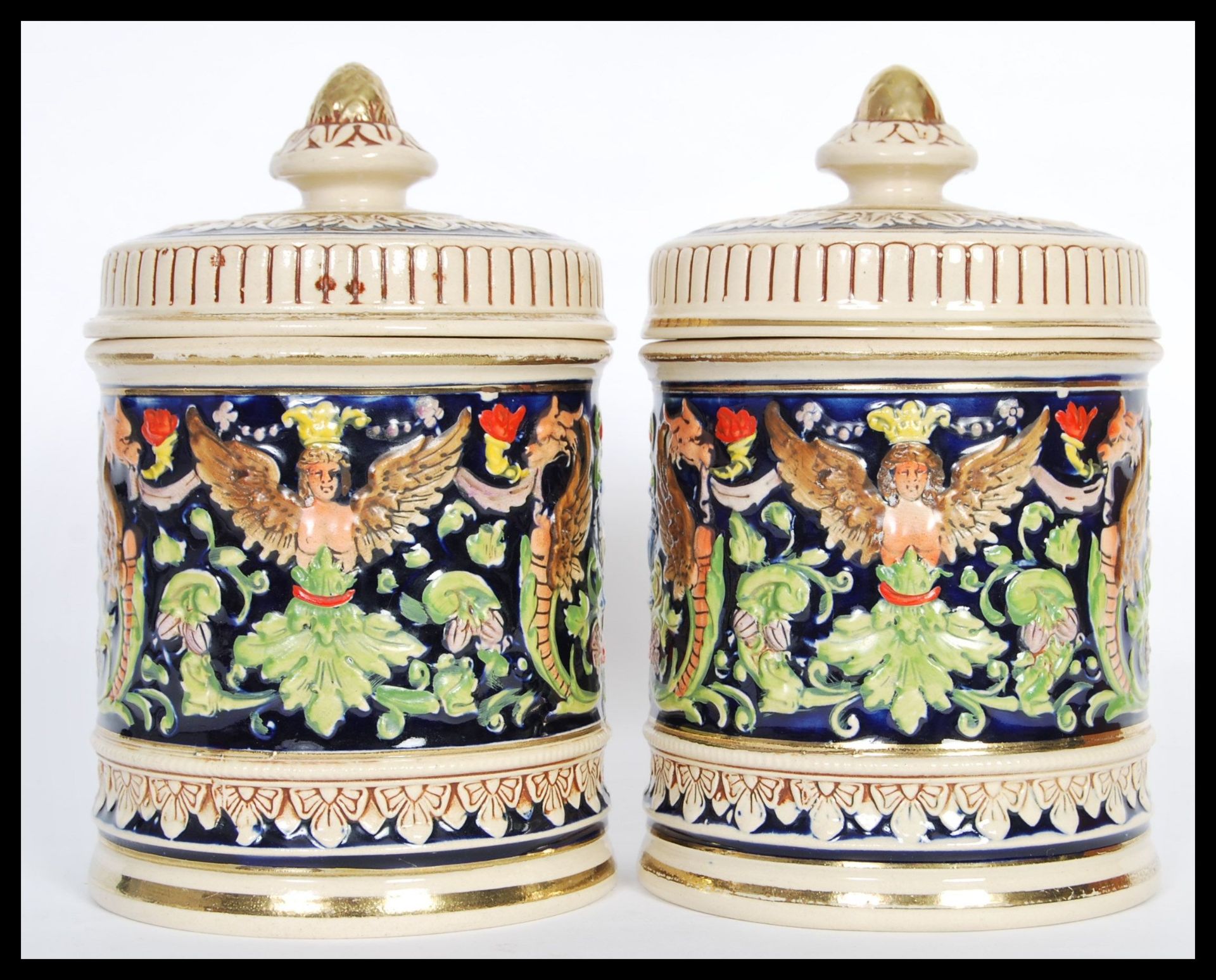 A pair of 20th Century German ceramic biscuit barrels / tobacco jar pots having hand painted