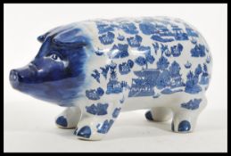 A vintage 20th Century large ceramic money bank box in the form of a pig having blue and white