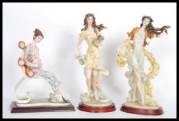A collection of three 20th Century Tenby cast resin figurines on round wooden plinth bases to