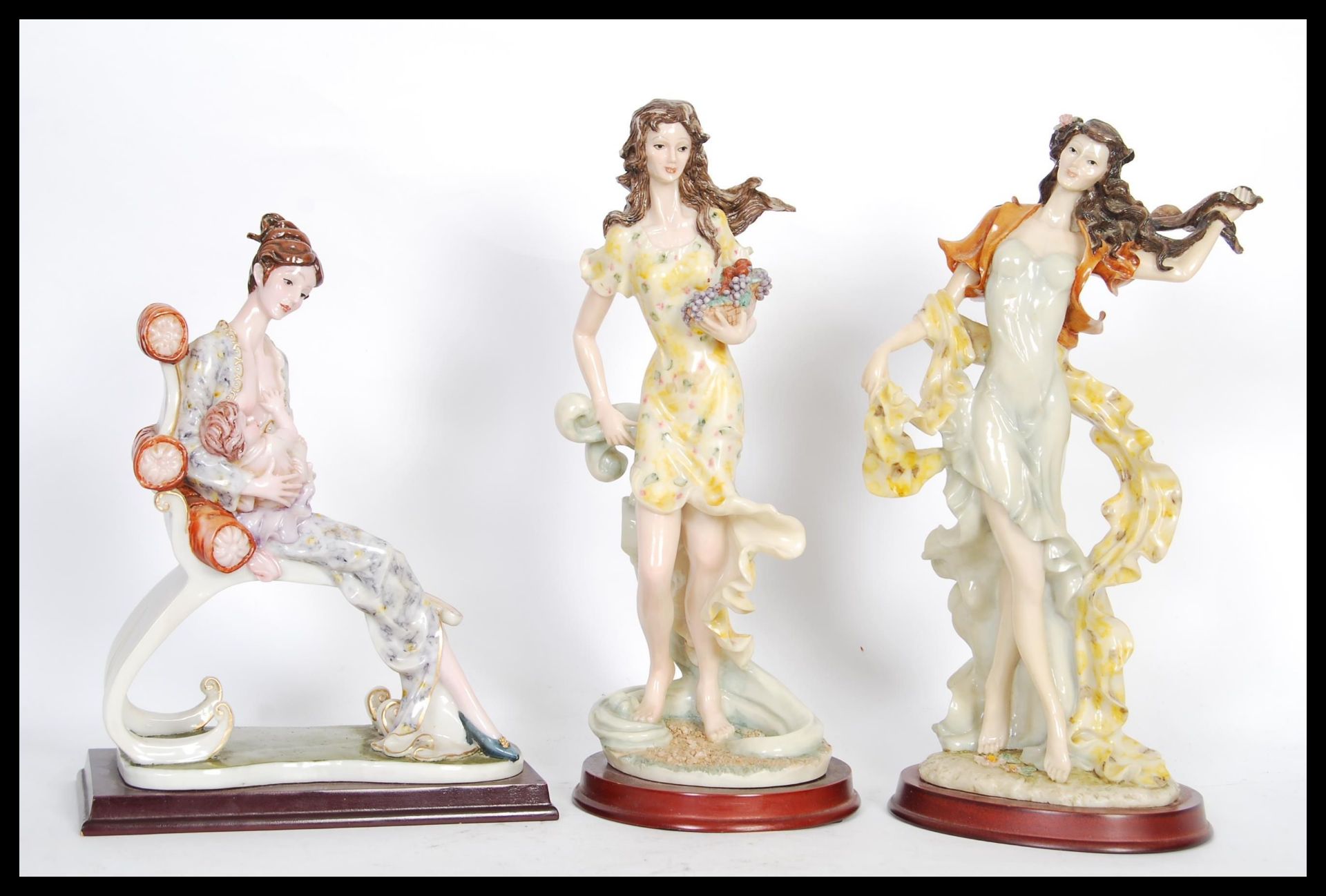 A collection of three 20th Century Tenby cast resin figurines on round wooden plinth bases to