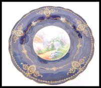 An early 20th Century Royal Worcester hand painted cabinet plate depicting a flower arch and cottage