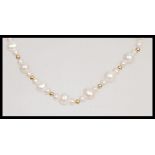 A 20th Century pearl necklace having repeating graduation design with a yellow metal pearl clasp.