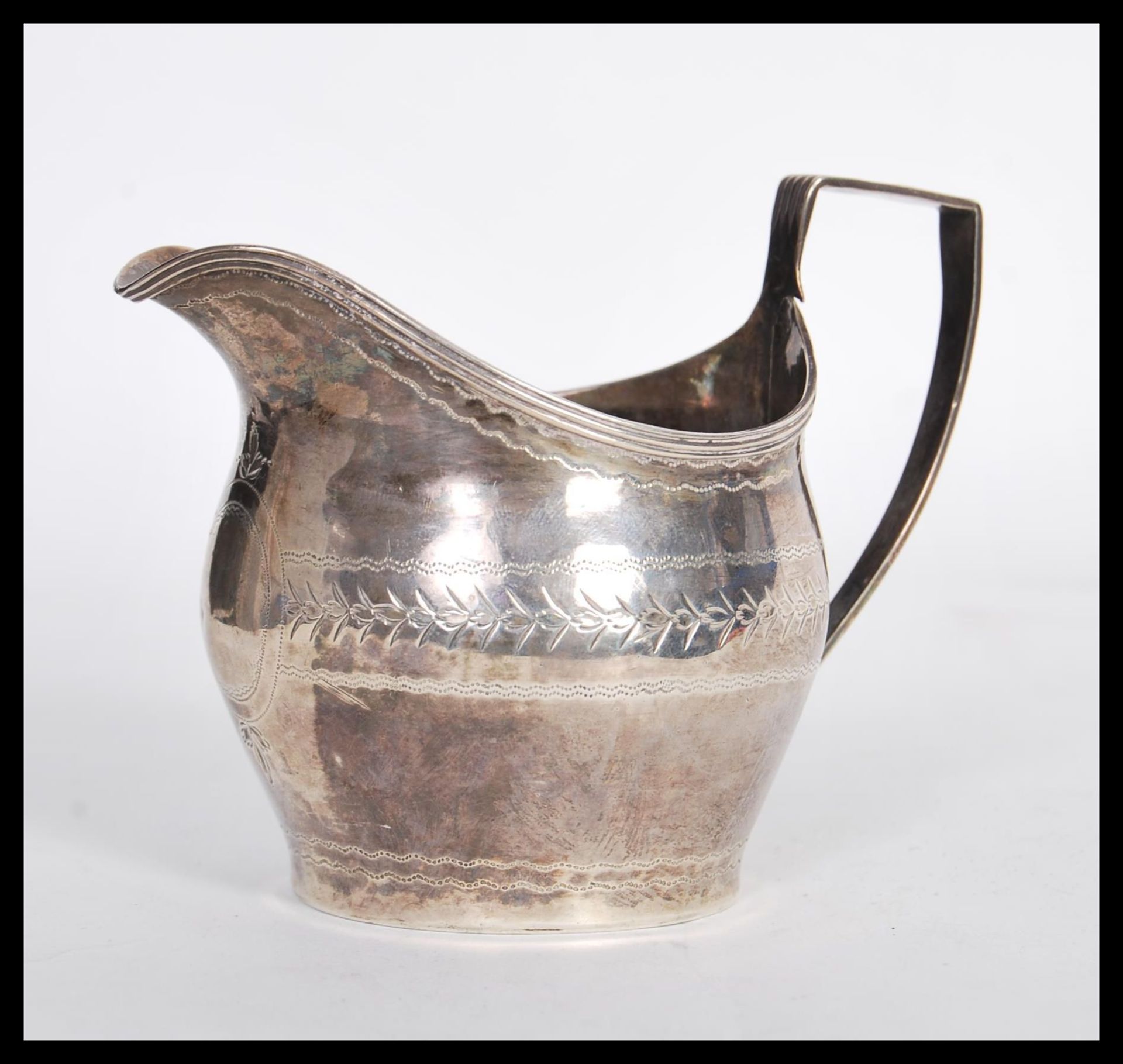 An early 19th Century Georgian hallmarked silver creamer jug having shaped handle. Hallmarked for