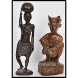 Two early 20th Century carved wooden figurines comprising of a Javanese cockfighter having a Kris