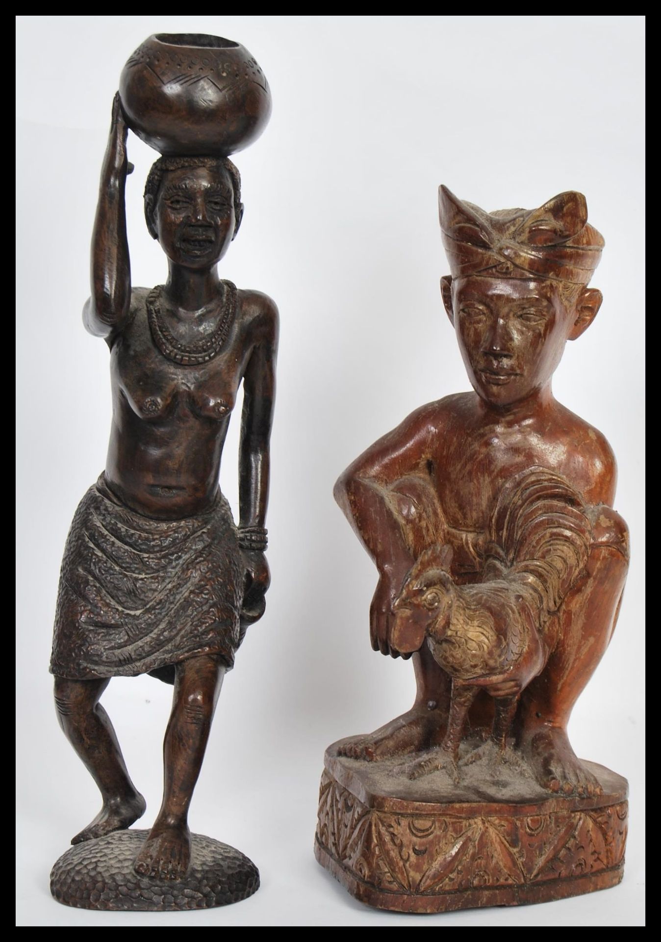Two early 20th Century carved wooden figurines comprising of a Javanese cockfighter having a Kris