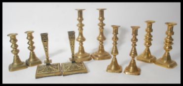 Five pair of antique brass candlesticks dating from the 19th Century to include pusher examples,