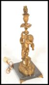 A 20th Century French cast metal gilt table lamp inthe form of a cherub on a turned column raised on