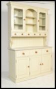 A Victorian style country painted pine kitchen dresser raised on large drawered base with glazed