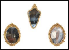 A group of three antique style gilt framed wall mirrors to include a matching pair with scrolled