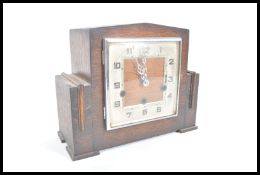 A 20th century Art Deco mantel clock having squarer silver dial chrome glaze door in a mahogany case