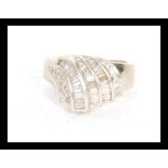 A hallmarked 18ct white gold ring set with three rows of step cut diamonds to the head. Hallmarks
