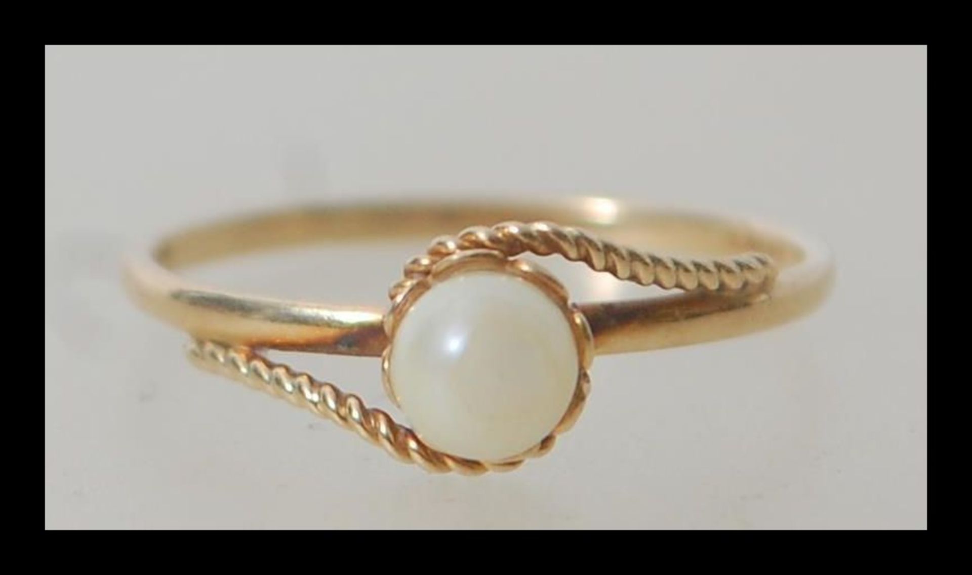 A 9ct 375 gold pearl solitaire ring having a 1.5mm half round shank with rope twist wire shoulders