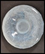A 20th Century opalescent glass bowl having relief decoration depicting fish in the manner of