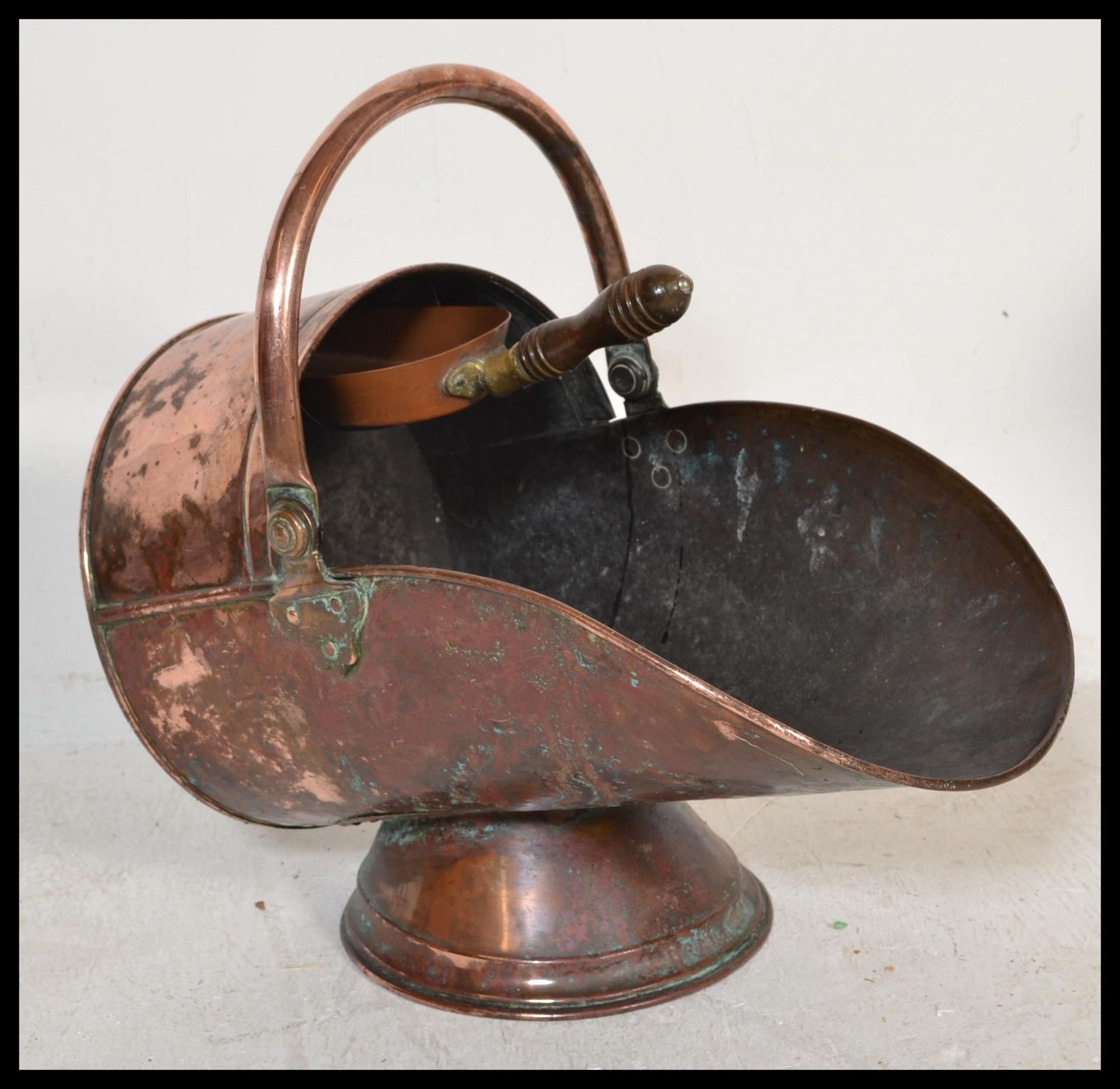 A 19th Century Victorian copper coal scuttle purdonium of helmet shape raised on a conical