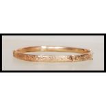 A hallmarked early 20th Century Edwardian 9ct gold bangle bracelet having a hinged opening and