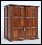 A 19th Century Victorian oak smokers cabinet in the folded linen / linen fold pattern having twin