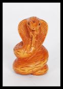 A 20th Century Japanese carved figurine of a snake having a carved character mark to the base.