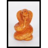 A 20th Century Japanese carved figurine of a snake having a carved character mark to the base.