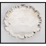 A 20h Century hallmarked silver salver tray plate of scalloped form raised on scrolled feet.