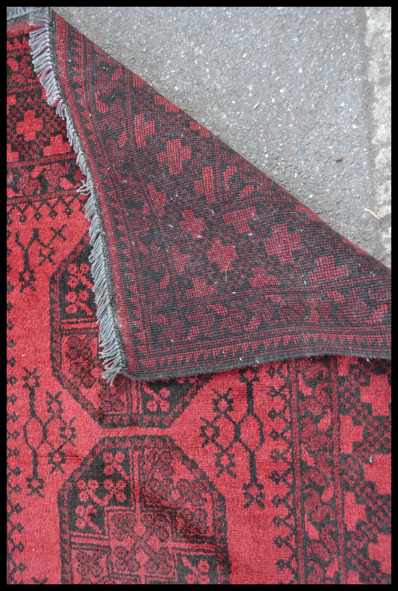 A 20th Century Persian Islamic floor rug / carpet having a red ground with black geometric borders - Bild 5 aus 5