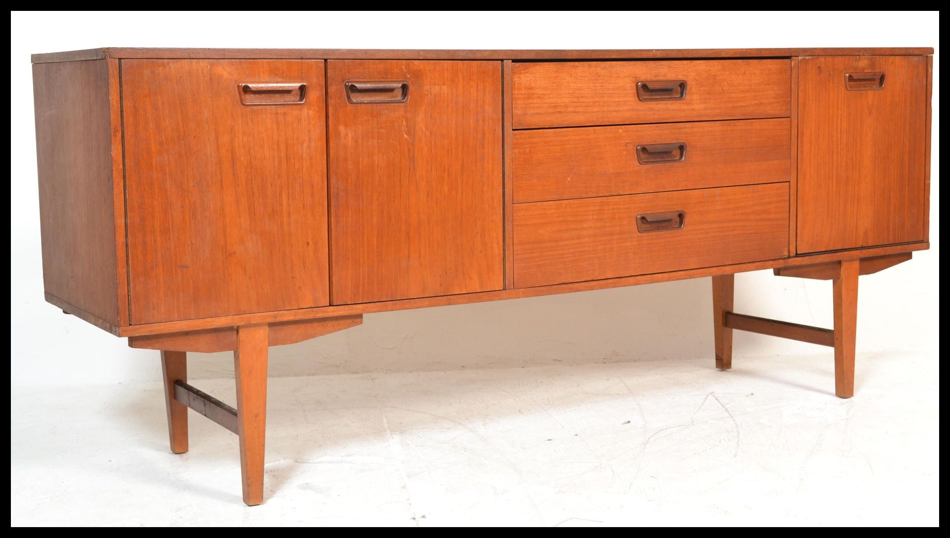 A retro 20th Century teak wood sideboard / credenza of Danish influence, having a central bank of