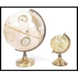 A graduating pair of vintage 20th Century desk top globes raised on circular brass bases. Measures