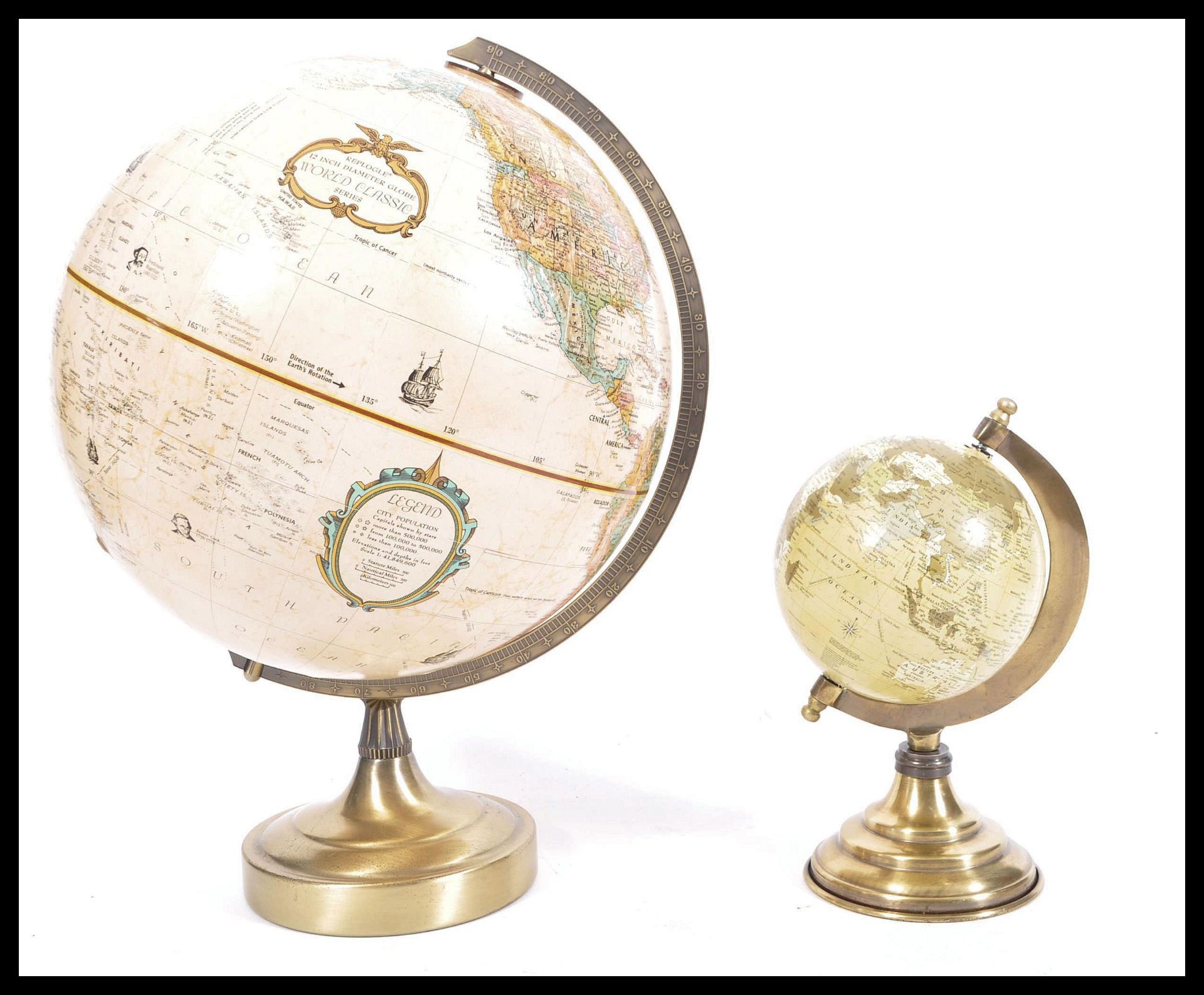 A graduating pair of vintage 20th Century desk top globes raised on circular brass bases. Measures