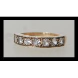 A hallmarked 9ct gold ring having seven flush set white stones. Size L.5. Weighs 3 grams.