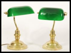 A pair of vintage 20th Century Bankers lamps raised on gilt brass circular bases with adjustable