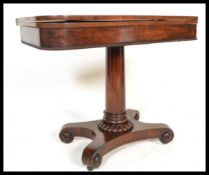 A 19th Century Mahogany tea / card table raised on fluted pedestal base with fold over top and