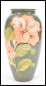 A large 20th Century Moorcroft pottery vase in the Hibiscus pattern. Green ground with tube lined