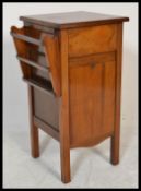 An early 20th Century walnut bedside table compendium of unusual form having a magazine rack to side