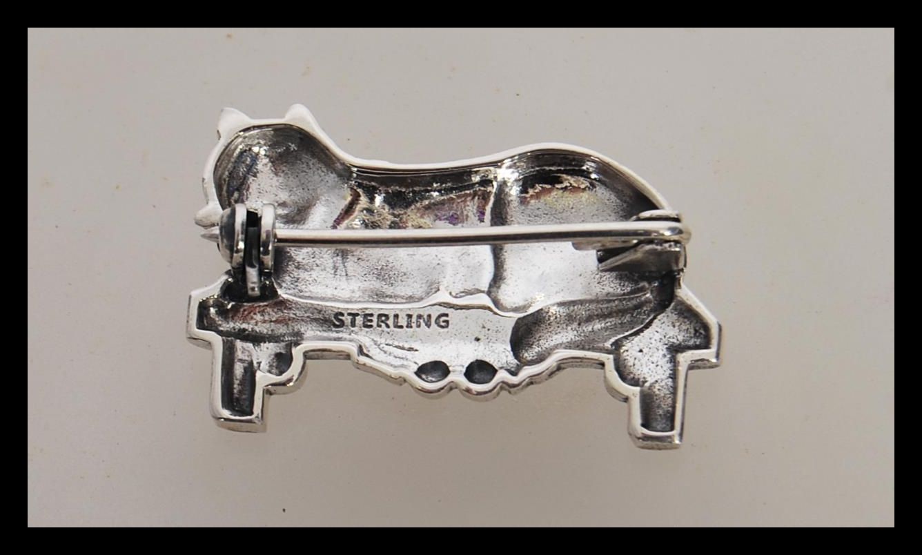 A stamped 925 silver brooch in the form of a cat sitting on a bench with a hinge pin to the verso. - Image 2 of 2