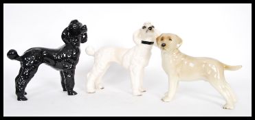 A group of three vintage 20th Century ceramic dogs to include a black and white poodle and a