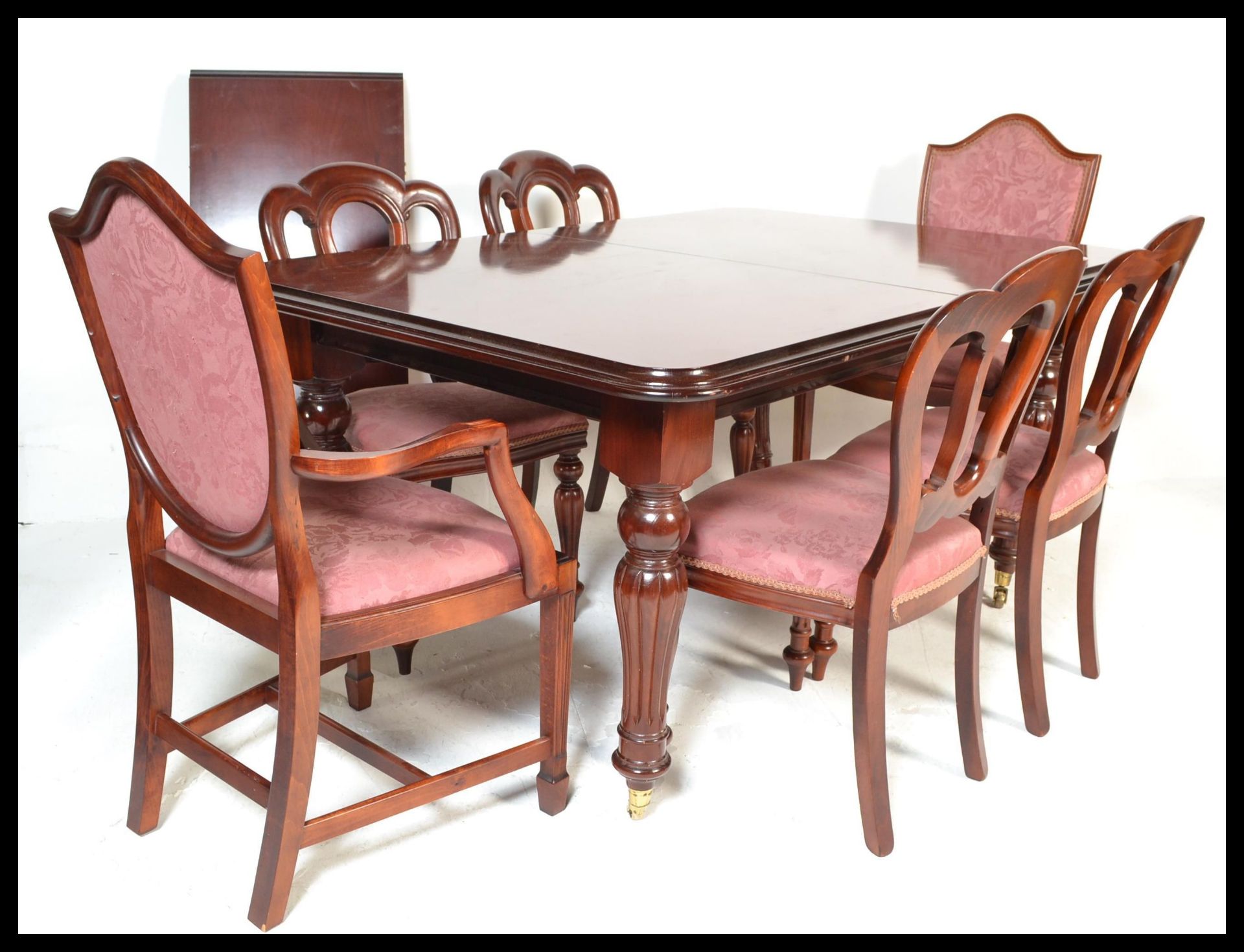 A large Victorian style mahogany wind out extending dining table being raised on reeded, turned