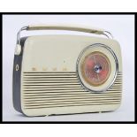 A vintage retro Bush radio having a cream plastic casing and tuning dial to the front, carrying